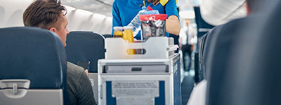 Azafata de línea aérea atiende a un pasajero.