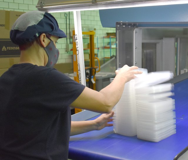 Fedinsa: Worker during the manufacturing process of transparent plastic containers.